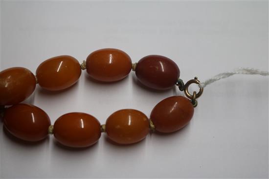 A single strand graduated oval amber bead necklace with 9ct gold clasp, gross weight 62 grams, 60cm.